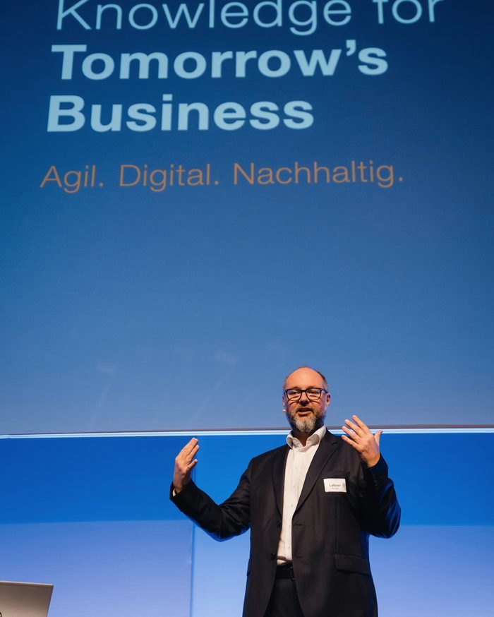 Othmar M. Lehner speaking in front of a screen reading Knowledge for Tomorrow's Business